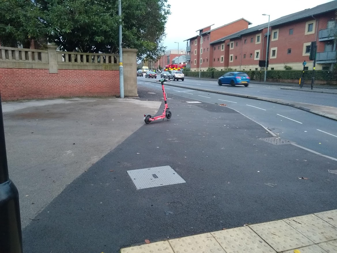 A Voi scooter parked in the middle of a large area of pavement