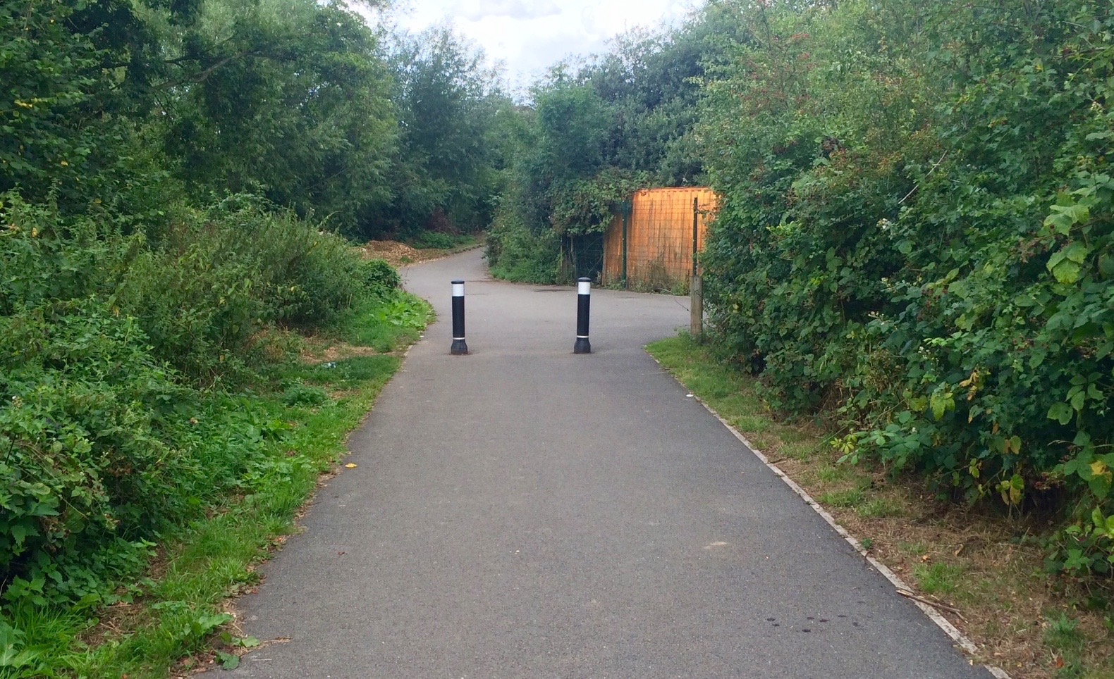 Two bollards preventing motor vehicle access to a shared use lane.