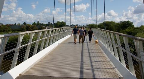 A family and their dog crossing Diglis Bridge