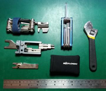 A selection of bicycle multitools, along with an adjustable spanner and a ruler for scale.